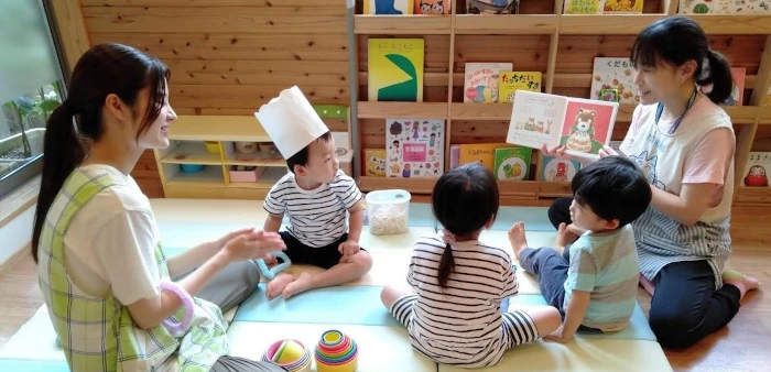 園で絵本の読み聞かせをしている保育士