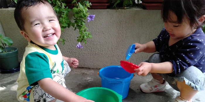 バケツで水遊びをする子供たち